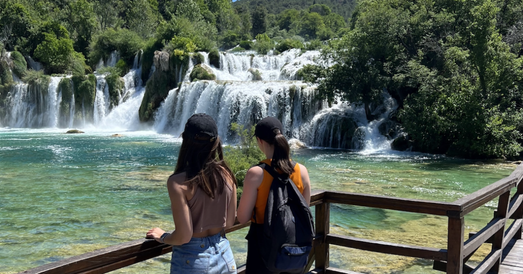 friends that solo travel watching waterfall in Greece